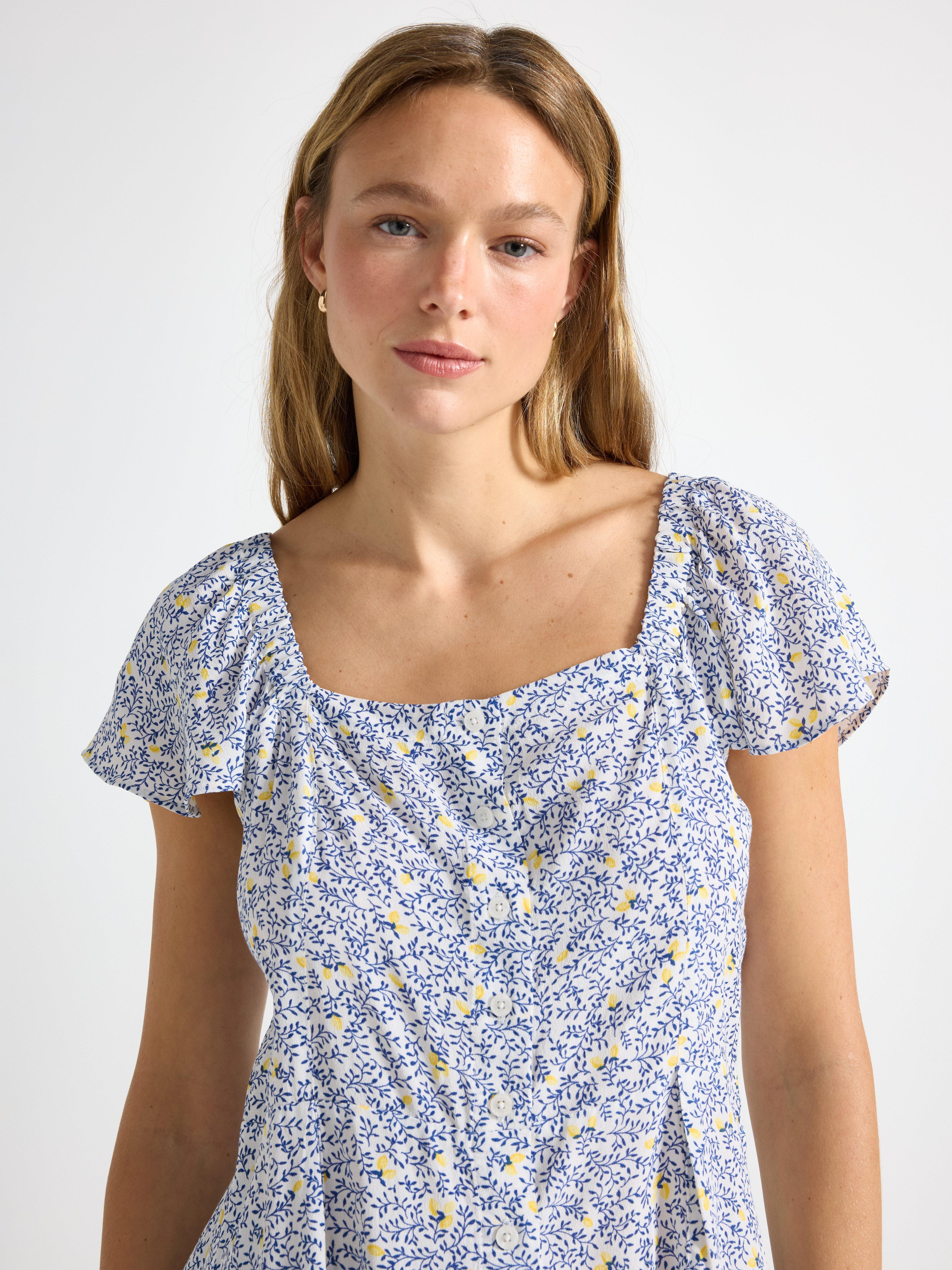 Blusa de manga corta, color blanco empolvado claro.