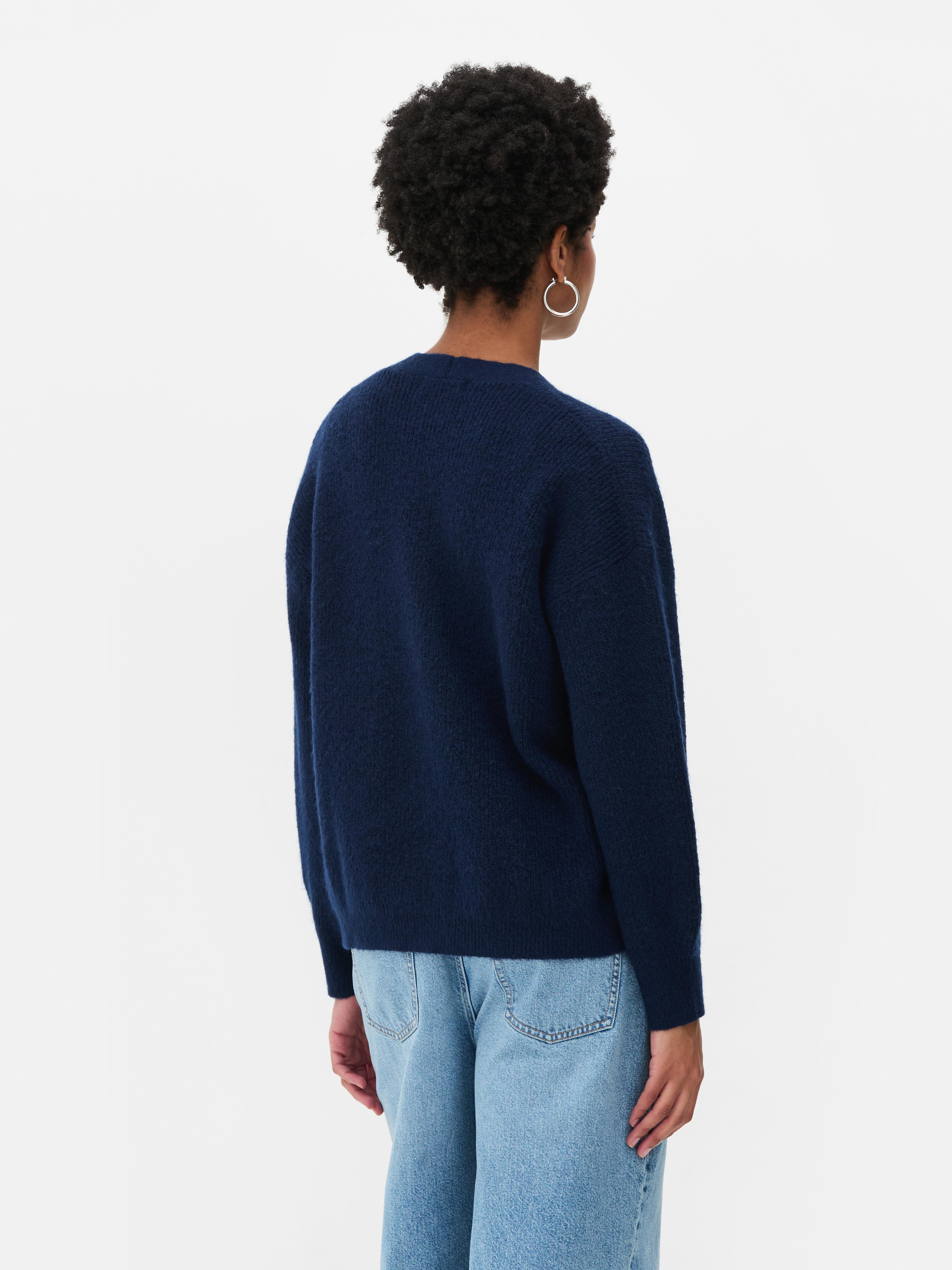 Cardigan cu decolteu în V și croială lejeră. Acest cardigan cu nasturi, croială lejeră și umeri căzuți este un clasic elegant.