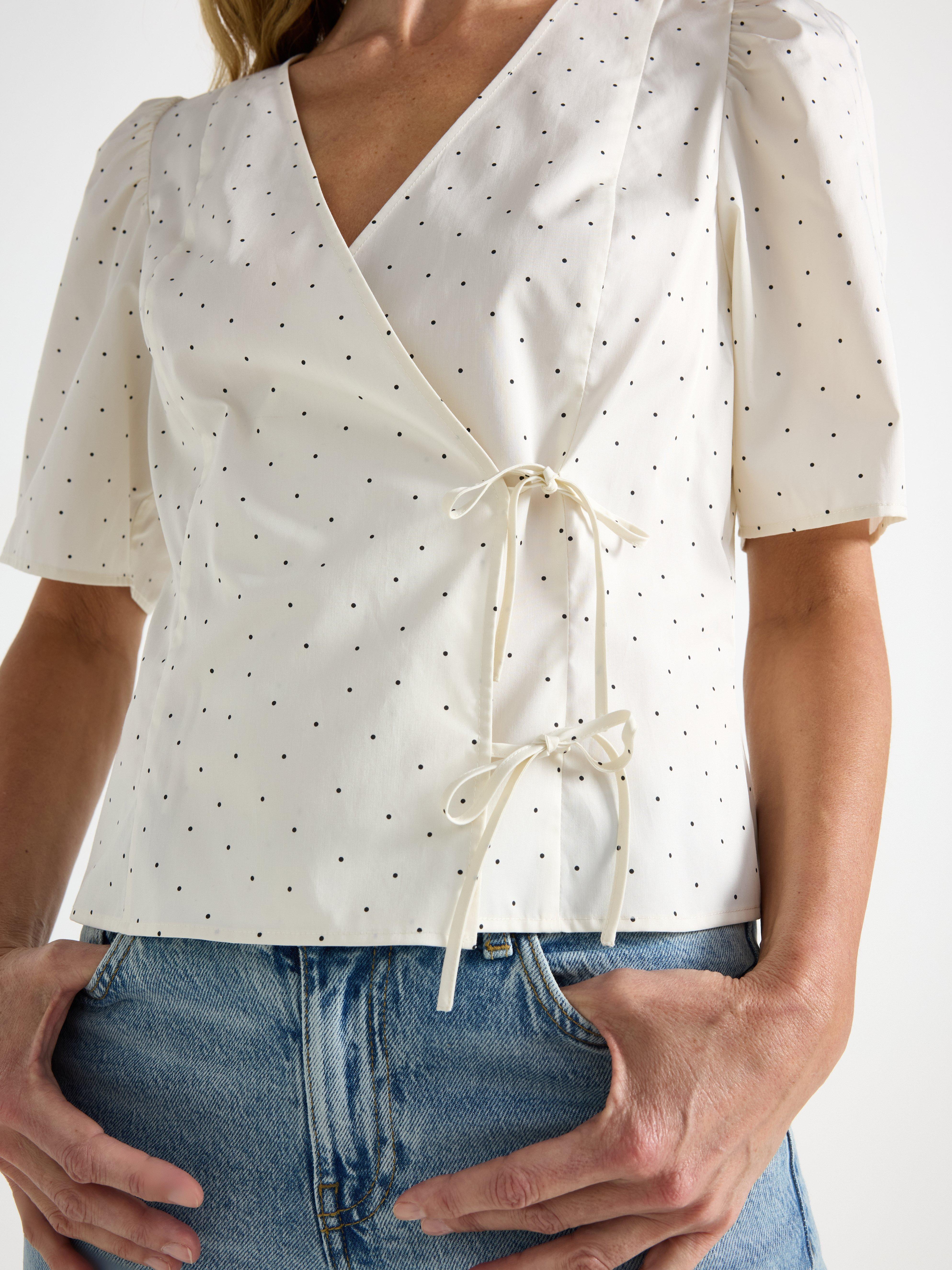 Blusa con diseño cruzado, color blanco claro.