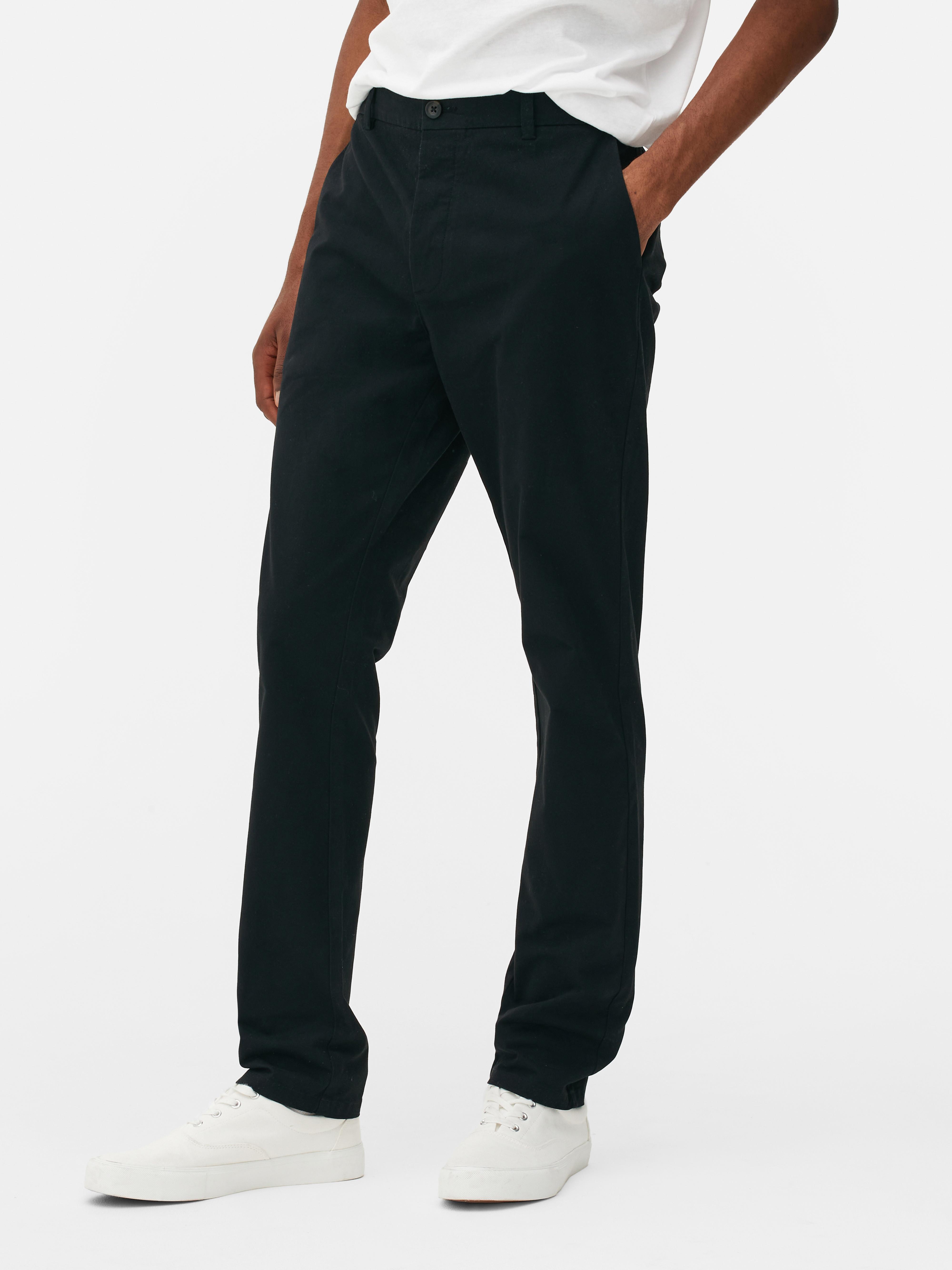 Pantaloni chino elastici, mulați. Pantaloni chino mulați, confecționați în principal din bumbac și cu buzunare laterale.