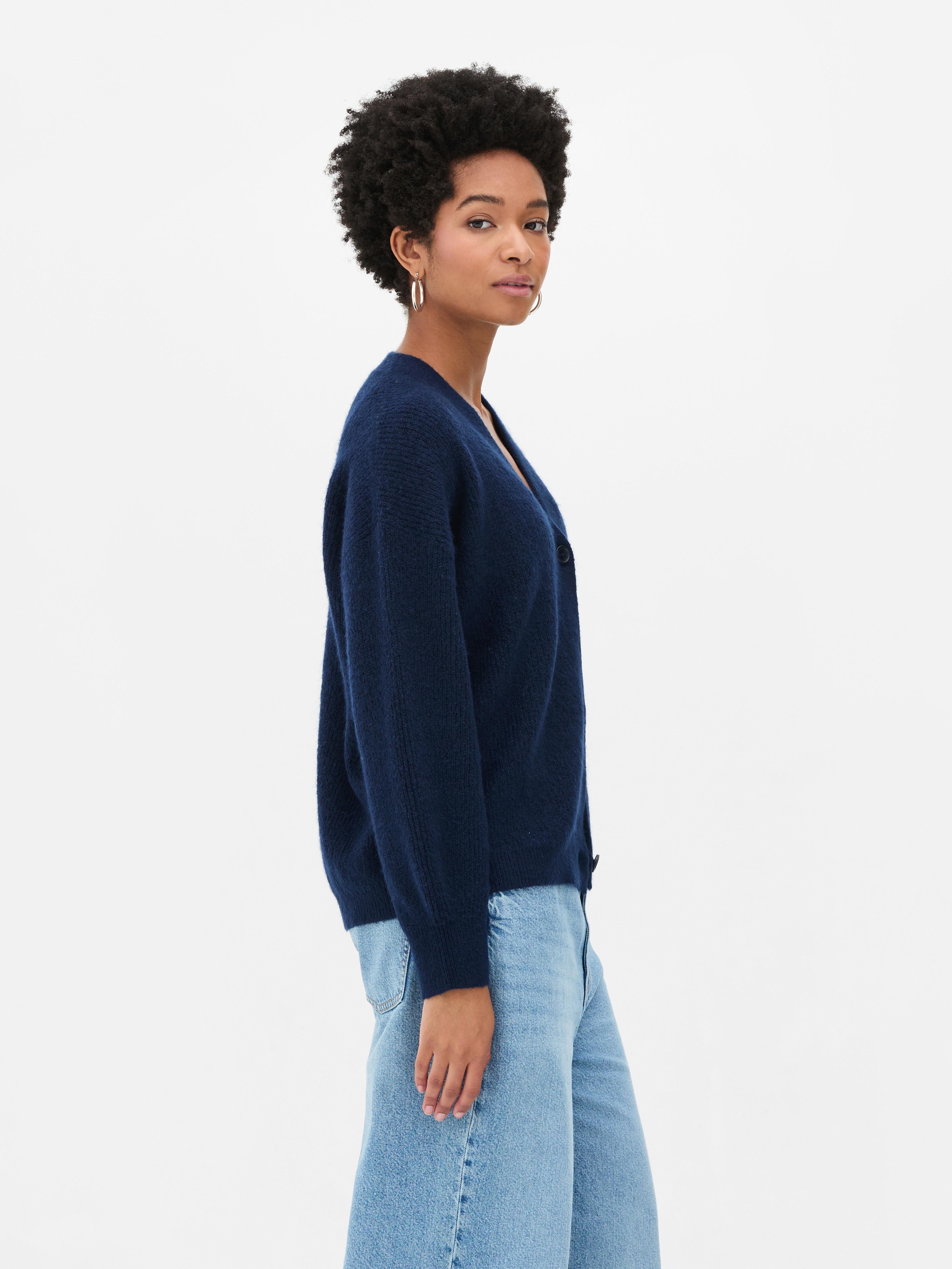 Cardigan cu decolteu în V și croială lejeră. Acest cardigan cu nasturi, croială lejeră și umeri căzuți este un clasic elegant.