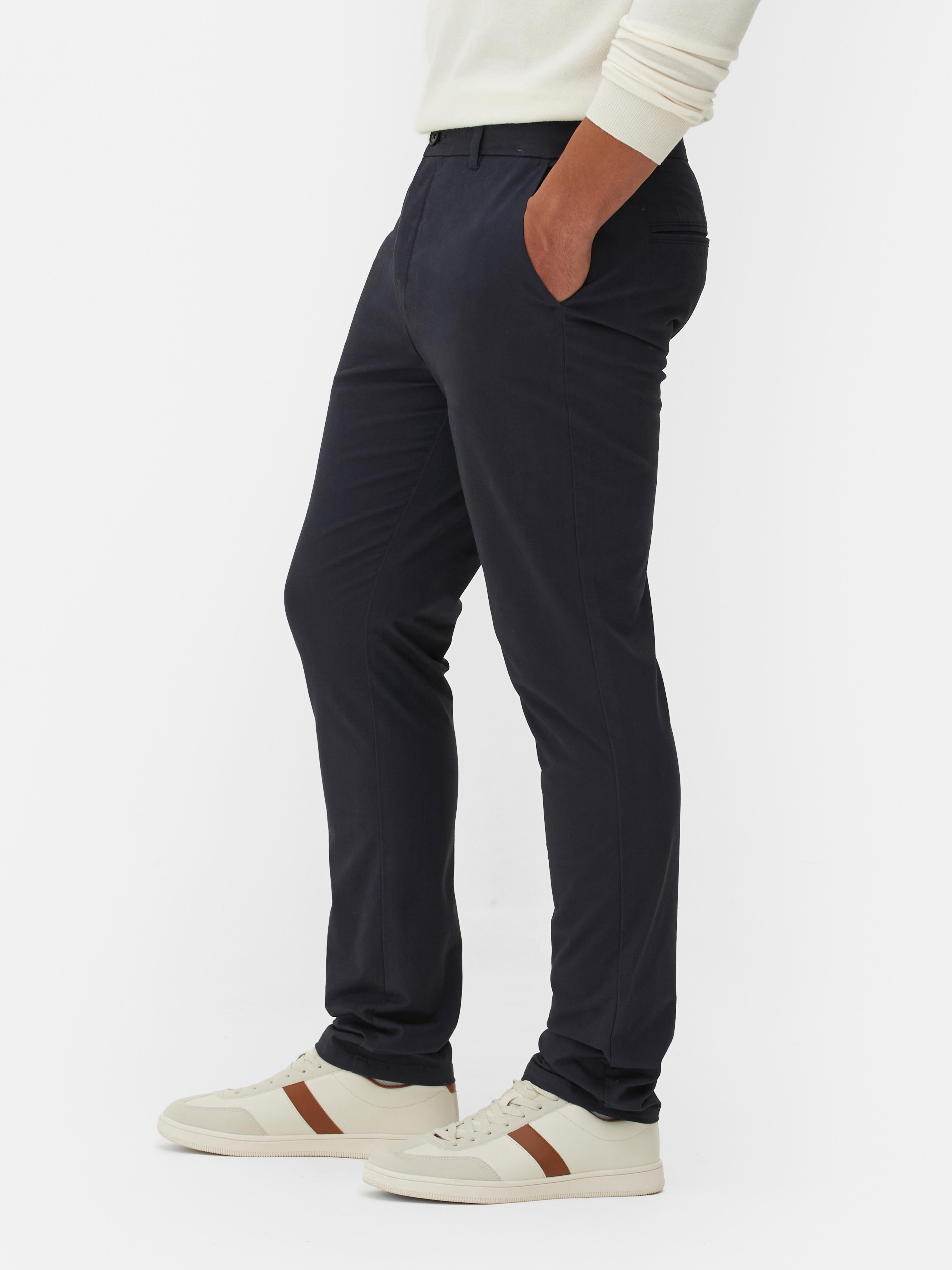 Pantaloni chino elastici, mulați. Pantaloni chino mulați, confecționați în principal din bumbac și cu buzunare laterale.