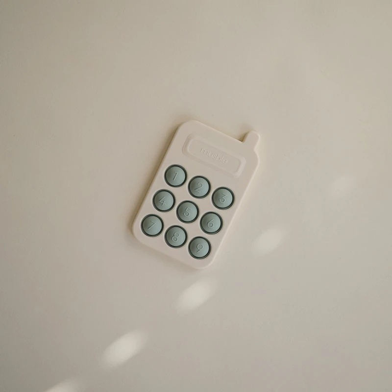 Izobraževalna igrača Mushie Pop-It Phone za otroke
