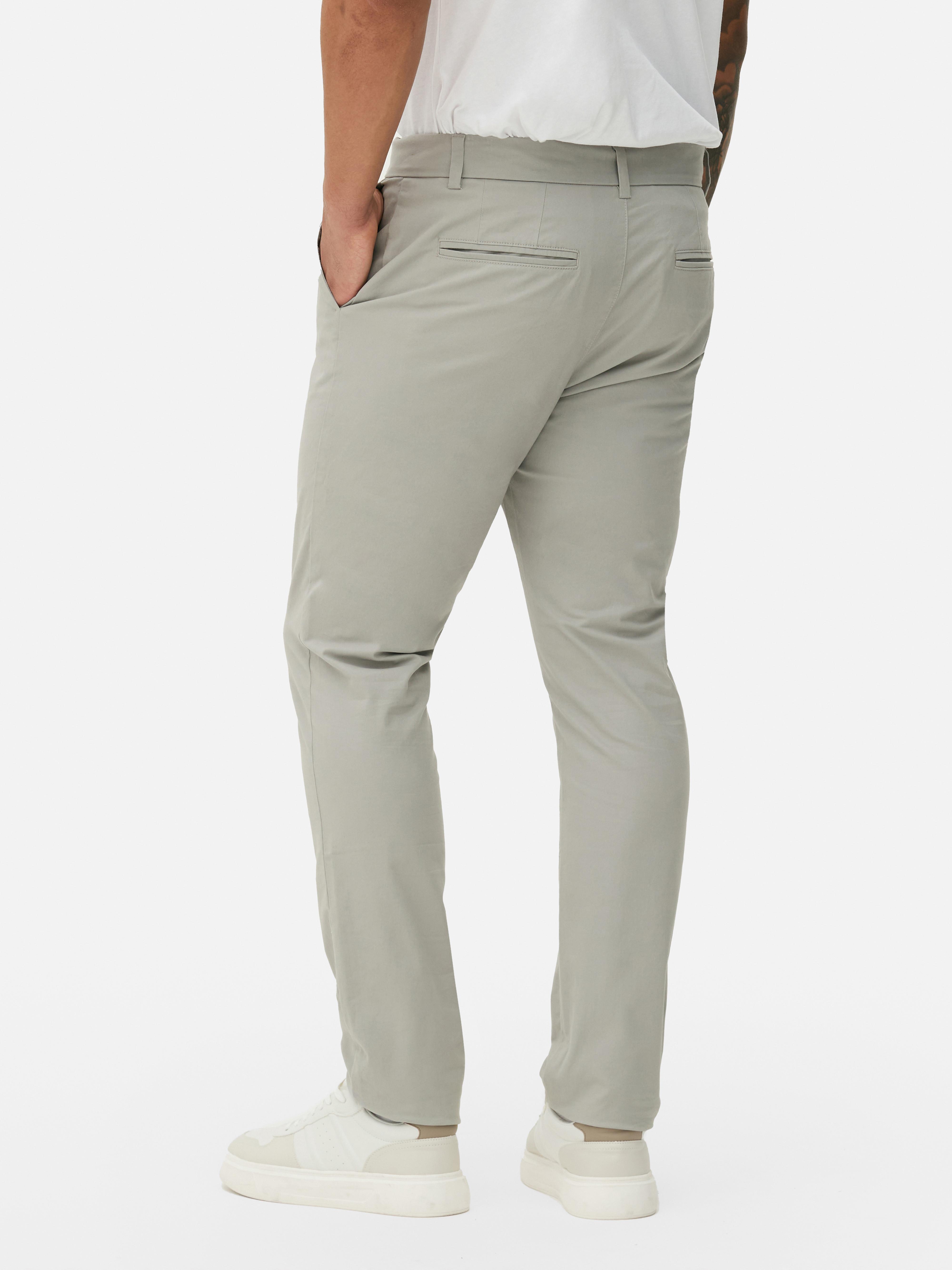 Pantaloni chino elastici, mulați. Pantaloni chino mulați, confecționați în principal din bumbac și cu buzunare laterale.