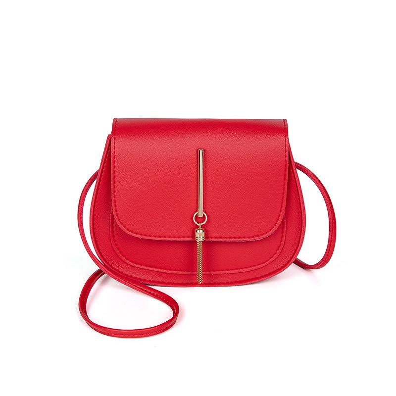 Sac bandoulière élégant en cuir uni pour femme, petit modèle, avec pompon métallique décoratif.