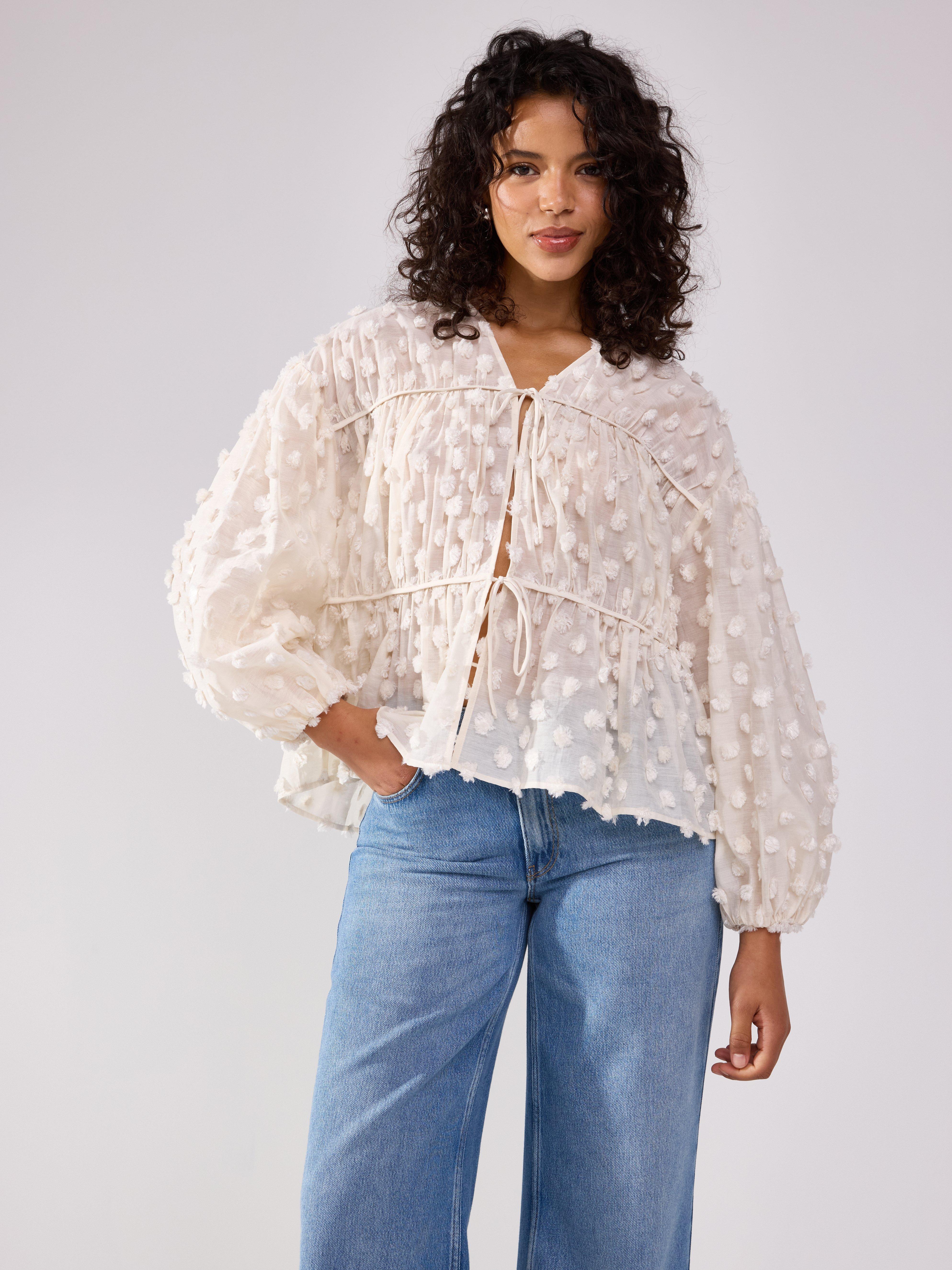 Blusa con lunares esponjosos, color beige claro.