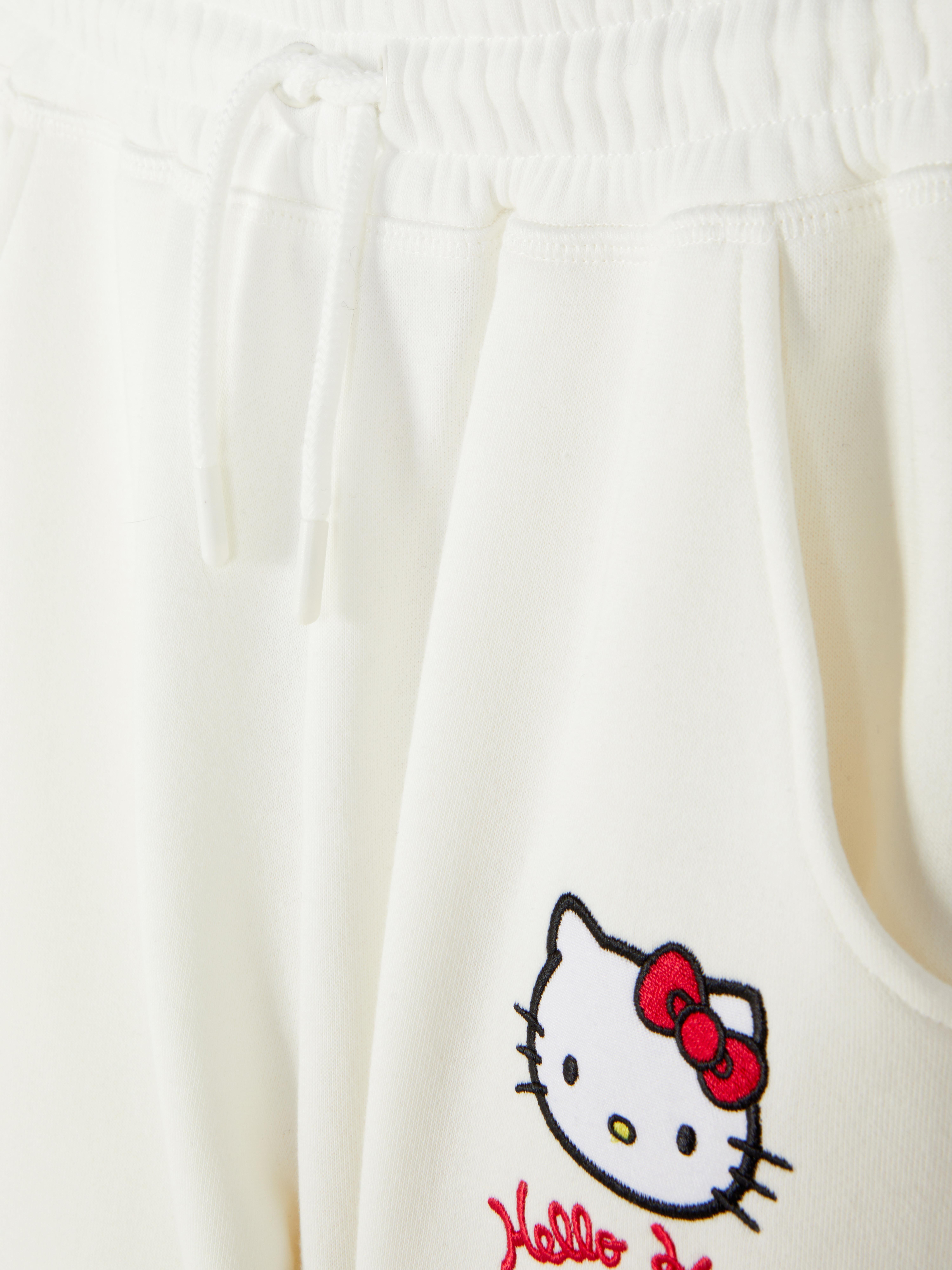 Pantaloni de trening cu croi larg, cu imprimeu Hello Kitty and Friends. Pantaloni de trening cu șnur de strângere, buzunare laterale, tiv despicat și design Sanrio.