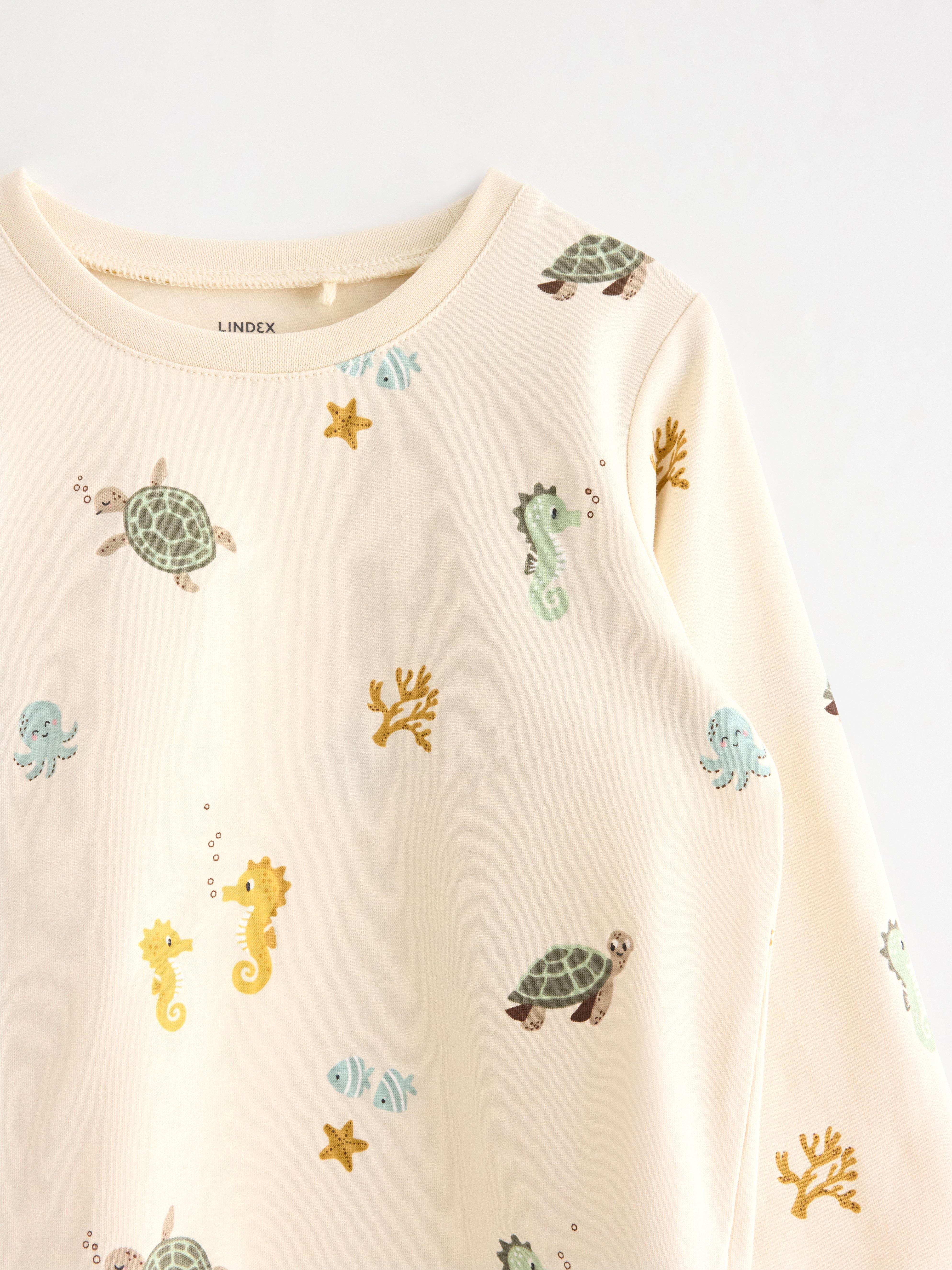 Top de manga larga color beige claro.