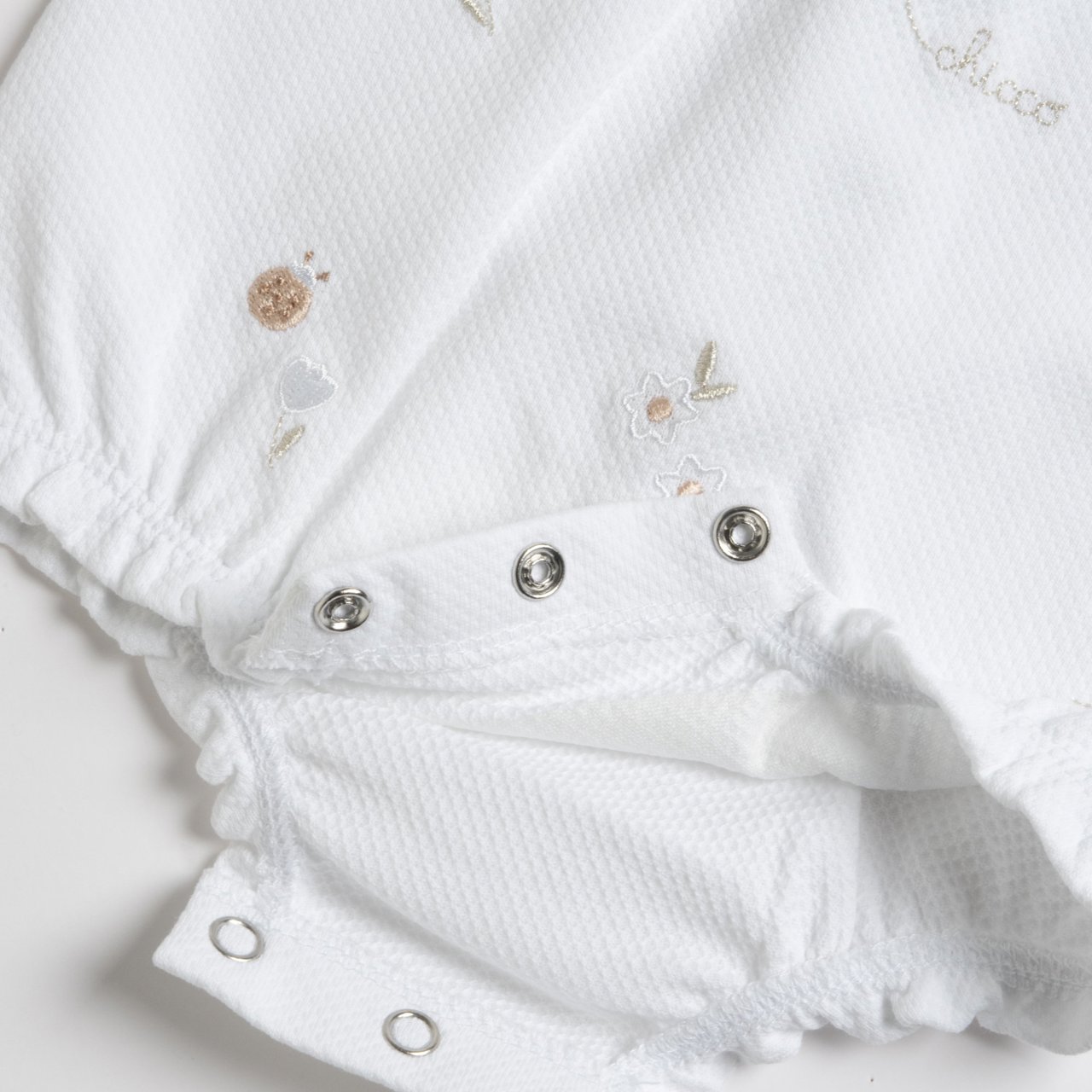 Beige geborduurde babyromper