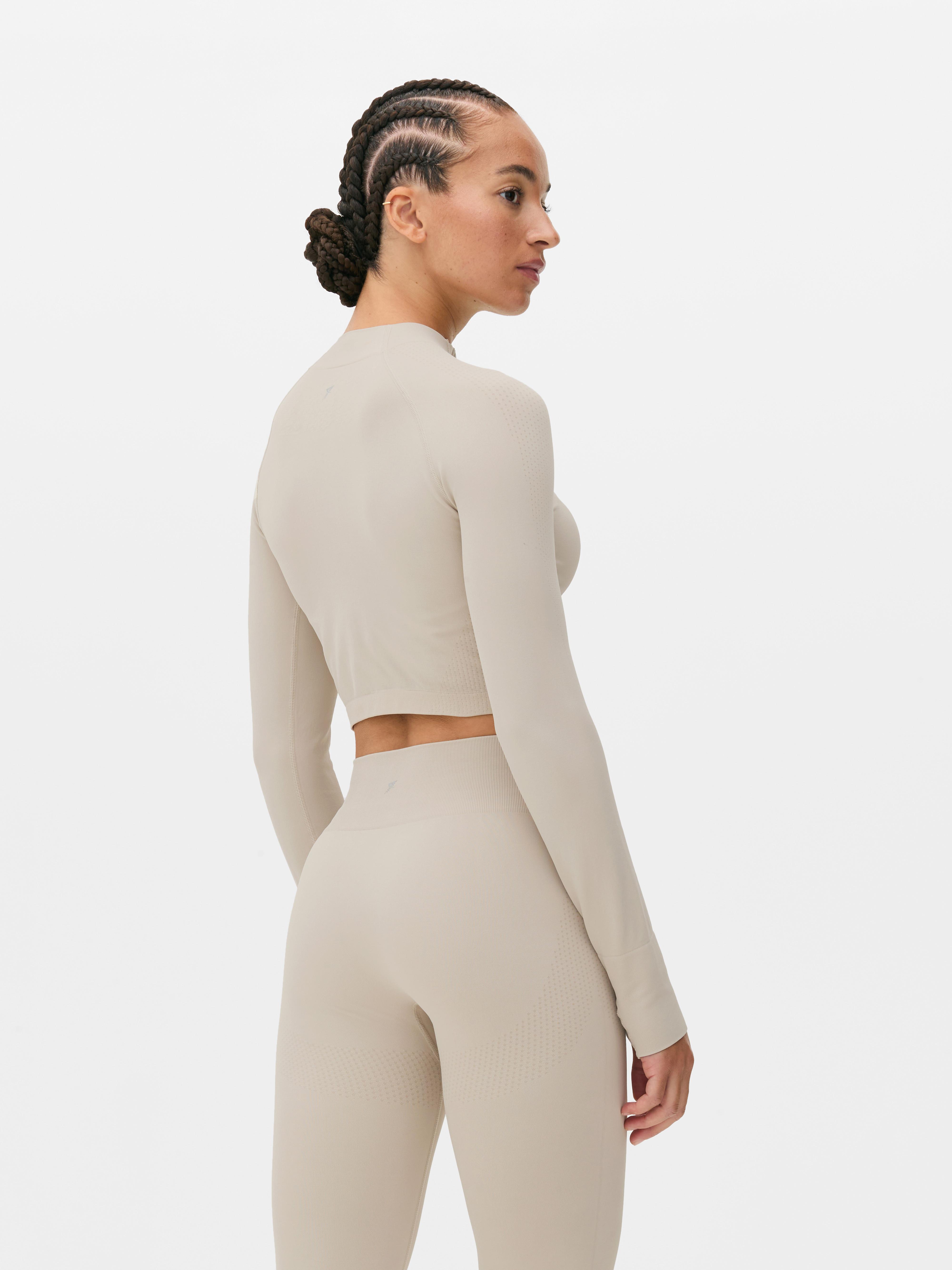 Top sport modelator cu mâneci lungi, fără cusături. Acest top sport scurt, cu fermoar pe jumătate și design fără cusături, este funcțional și elegant.